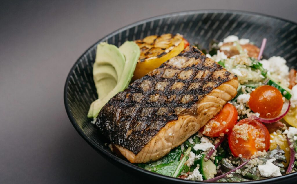 Grilled steak with potatoes and vegetables on a black plate