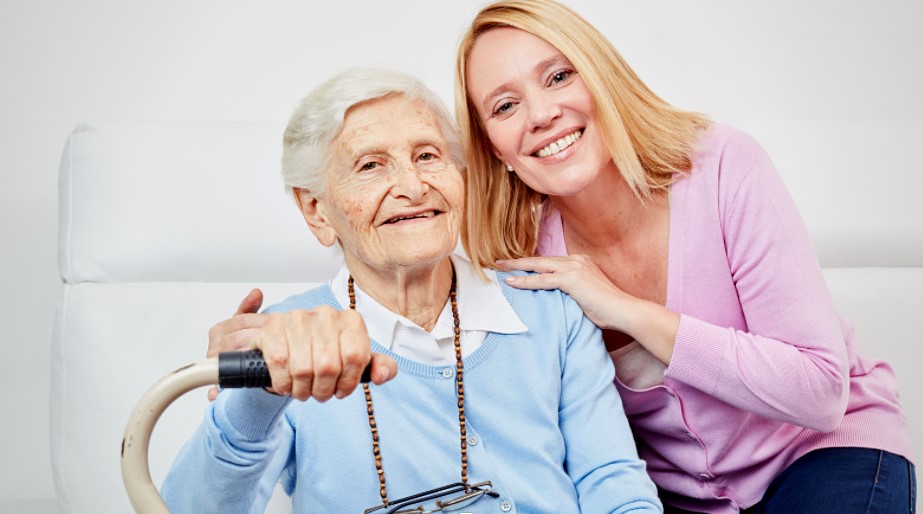 Senior woman seated with adult woman standing beside her